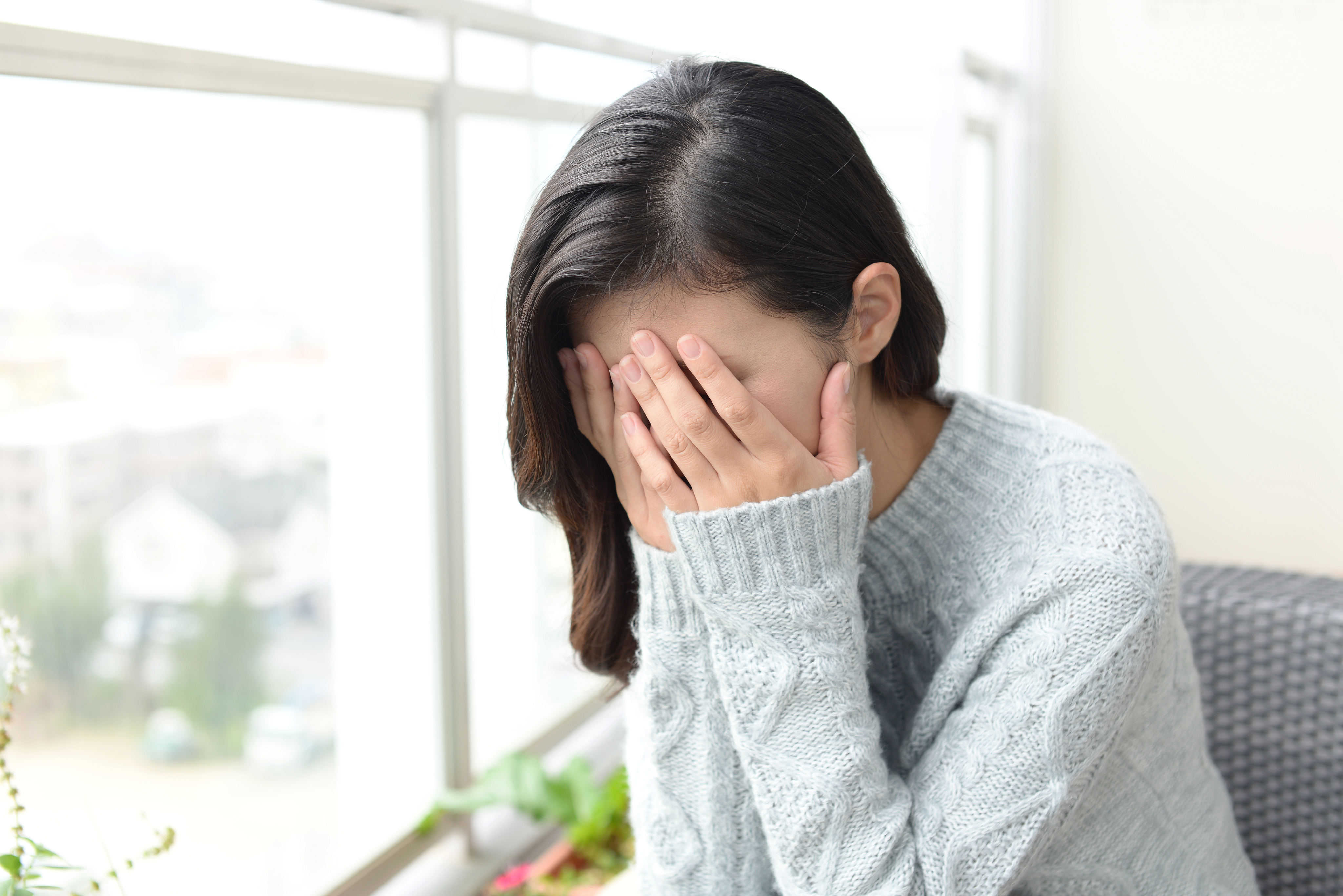 顔を両手で覆い、泣きくずれている女性